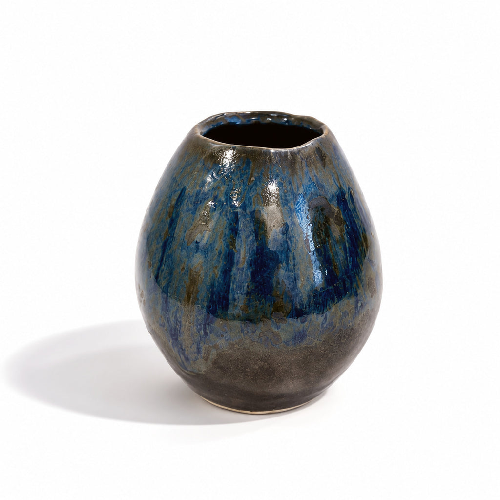 A small rounded ceramic vase with a glossy blue and dark brown glaze, photographed on a clean white background with a soft shadow.